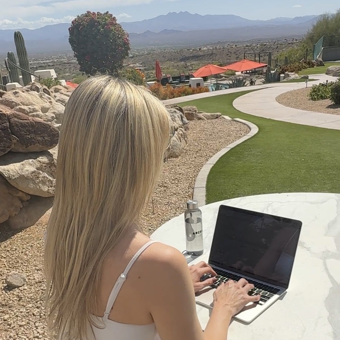 Melissa Agnes working on her laptop outdoors